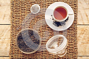 Tea set with hot water in cup on wooden table