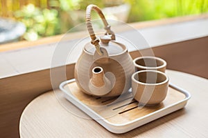 Tea set with kettle and traditional Japanese mugs on a wooden table