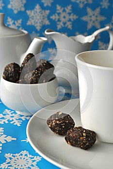 A tea set with raw walnut-date balls on blue winter background