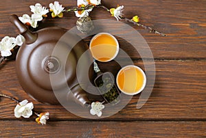 Tea set (teapot, cups and different green tea) a wooden background