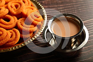 Tea and snacks- murukku or chakli. served in brass plate.