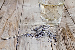 A tea spoon of dried lavender on wood table