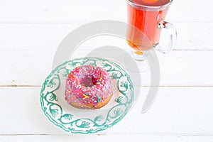 Tea and sugar donut on white wooden table