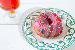 Tea and sugar donut on white wooden table