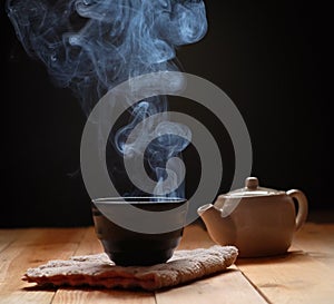 Tea in teapot and cup with steam