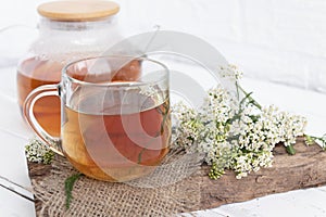 tea in a teapot (decoction)from the leaves and flowers of medicinal yarrow (Achillea) in a cup