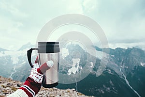 Tea in thermos over mountains view