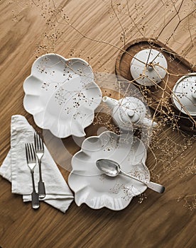 Tea time. Beautiful dishes on a wooden table - dessert plates, cutlery, teapot, top view