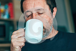 Tea time, casual adult man drinking hot tea beverage from white cup photo