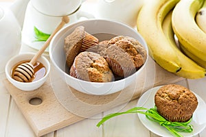 Tea time: homemade banana muffins, honey, bananas and tea settings
