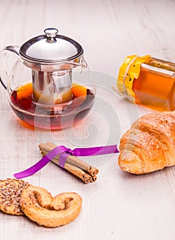 Tea in a transparent cup, cinnamon and oat cookie