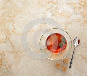 Tea in a transparent glass mug with saucer