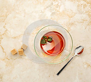 Tea in a transparent glass mug with saucer