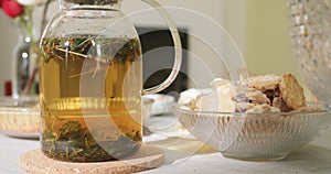 Tea in a transparent teapot on the table with cookies on a plate. Herbal tea.