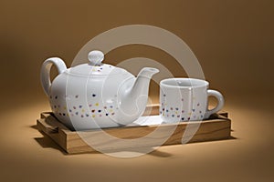 tea tray, with a round teapot and a cup, photographed in an intimate setting