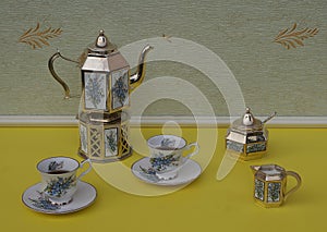 Tea for two, english teacups, saucers, silver-plated teapot on a silver stove, cream jug, sugar bowl and sugarspoon
