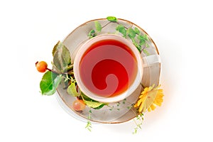 Tea with various ingredients. Teacup and herbs, fruits, and flowers, top shot