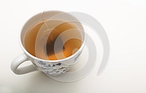 Teabag steeping in boiling water in a teacup