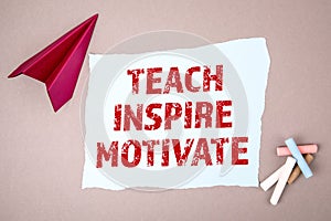 TEACH, INSPIRE and MOTIVATE concept. Text on note sheet, paper plane, symbol of gaining goals