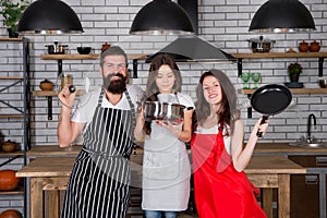 Teach kid cooking food. Cooking together. Together is more tasty. Mom dad and daughter aprons in kitchen. Cooking