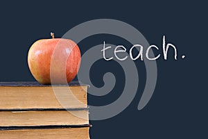 Teach written on blackboard with apple and books