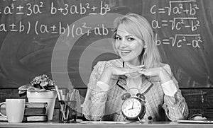Teacher with alarm clock at blackboard. Time. Study and education. Modern school. Knowledge day. woman in classroom