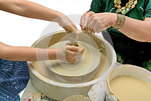 Teacher and apprentice. Revival of folk crafts. Shaping clay on pottery wheel. Creative lesson. Isolated