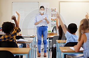 Teacher asking questions to school kids who are eager, smart and clever for education in covid pandemic. Students