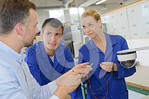 Teacher asking student to connect electric cable