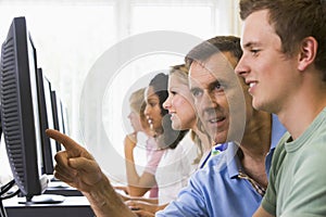 Teacher assisting college student in computer lab photo