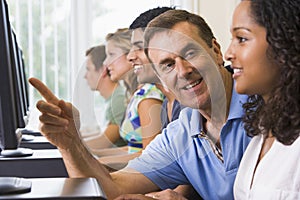 Teacher assisting college student on computers