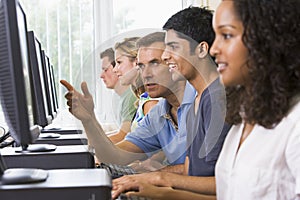 Teacher assisting college student on computers