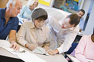 Teacher assisting mature student in class