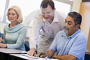 Teacher assisting mature student in class