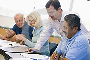 Teacher assisting mature student in class photo