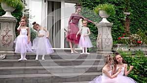 The teacher of the ballet does warm-up on a porch of ballet school. Ballerinas do warm-up