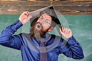 Teacher bearded man with modern laptop chalkboard background. School blows his mind. Hipster teacher aggressive with