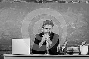 Teacher bearded mature schoolmaster listening with attention. Teacher formal wear sit at table classroom chalkboard photo