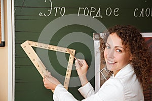 Teacher at blackboard with ruler and pencil