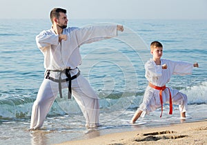 Teacher and boy doing karate poses