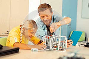 Teacher building a robot with one of his pupils.