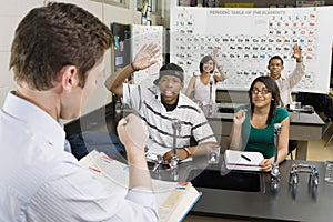 Teacher Calling On Students In Science Class