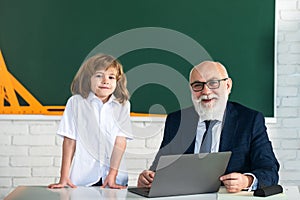 Teacher and child. Back to school. Education and learning in school. Schoolboy in classroom. Old teacher and young pupil