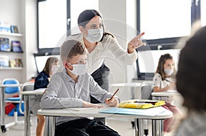 Teacher and children with face mask back at school after covid-19 quarantine and lockdown.