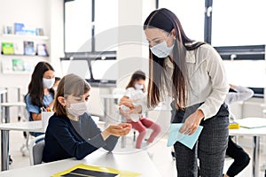 Teacher, children with face mask at school after covid-19 quarantine and lockdown.