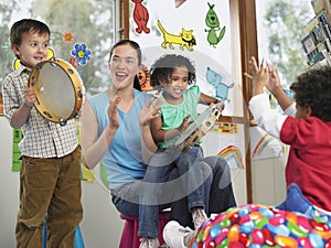 Teacher With Children Playing Music In Class
