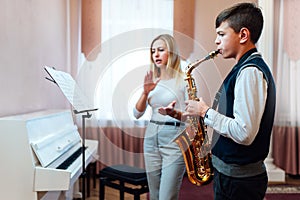 Teacher claps instead of a metronome for a student on saxophone in music lesson that focuses on playing photo