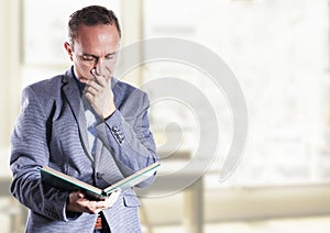 Teacher in the class room holding an album or book and thinking about some issue