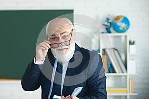 Teacher in the classroom near the blackboard is teaching a lesson. Professor at the university is giving a lecture.