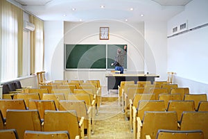 Teacher clears with blackboard in empty classroom,